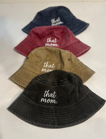 Four bucket hats in different colors with 'that mom' text on a light background