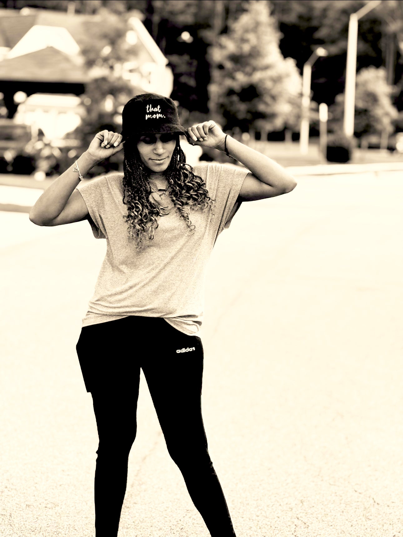 Person wearing a that mom cap and Adidas pants outdoors